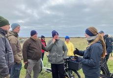 Dr. Corinna Langebrake, Mitarbeiterin des LIFE GrassBirdHabitats erklärt den Gästen, wie eine wiesenvogelfreundliche Bewirtschaftung der Flächen auf Langeoog mit Hilfe von Beweidung umgesetzt wird